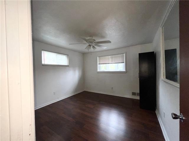 spare room featuring ceiling fan and dark hardwood / wood-style floors