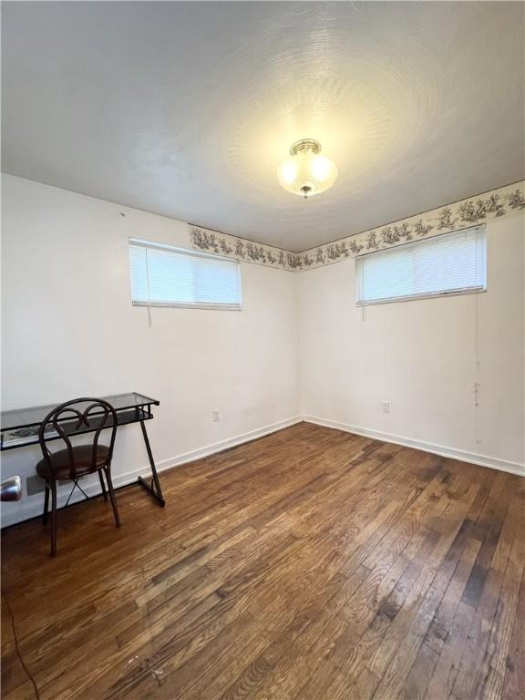 unfurnished room with hardwood / wood-style floors, baseboards, and plenty of natural light