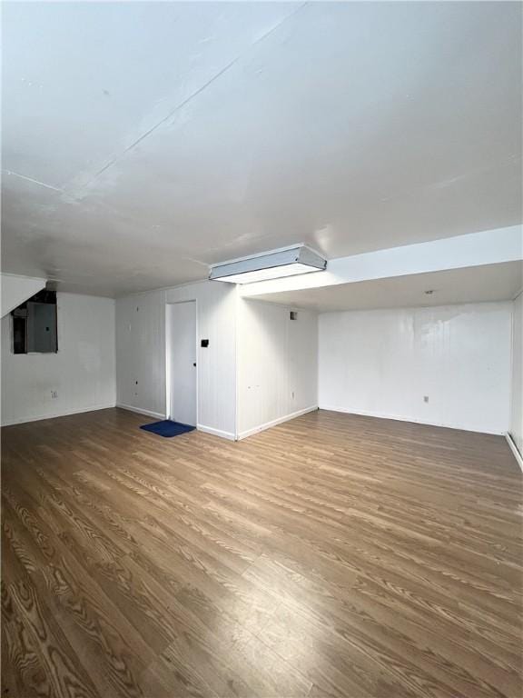 finished basement featuring electric panel and wood finished floors
