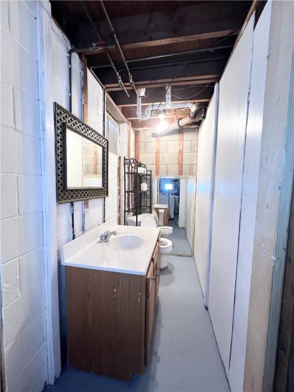 bathroom featuring toilet, concrete flooring, and vanity