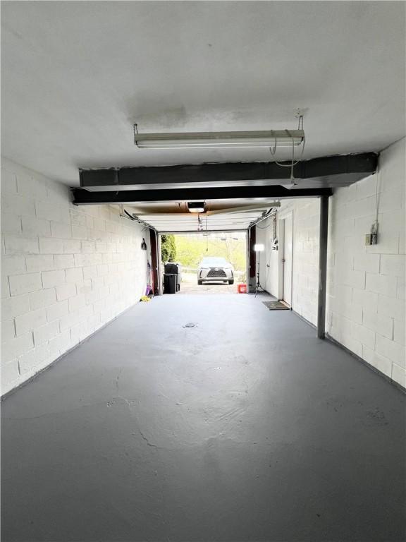garage with concrete block wall and a garage door opener