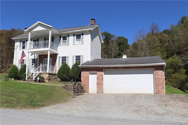 view of front of house with a balcony, a garage, and a front yard