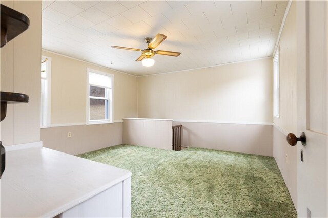 carpeted spare room featuring ceiling fan