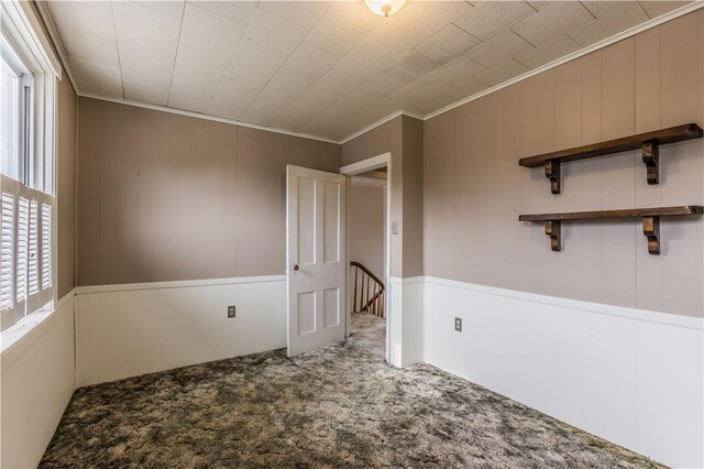 carpeted spare room with crown molding