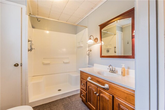 bathroom with walk in shower, ornamental molding, and vanity