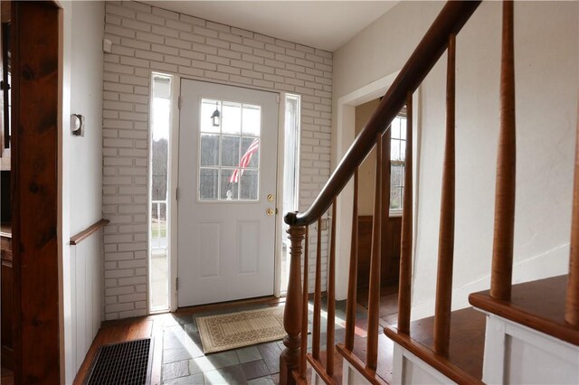 entryway featuring hardwood / wood-style flooring and brick wall