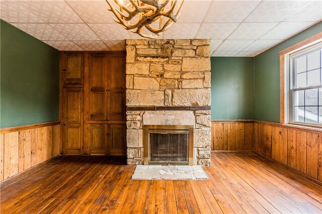 unfurnished living room with wooden walls, a fireplace, and dark hardwood / wood-style flooring