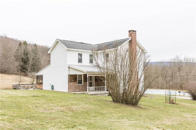 rear view of house with a yard and covered porch