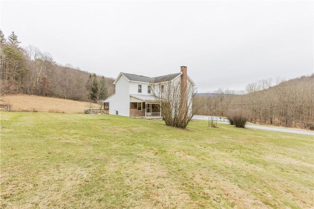 rear view of property with a porch and a yard