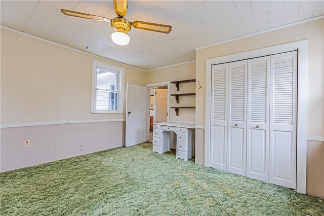 unfurnished bedroom featuring ornamental molding, carpet flooring, ceiling fan, and a closet