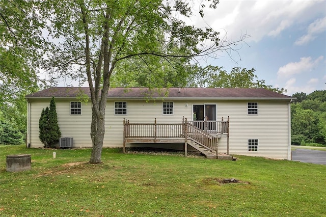 back of house with central air condition unit, a lawn, and a wooden deck