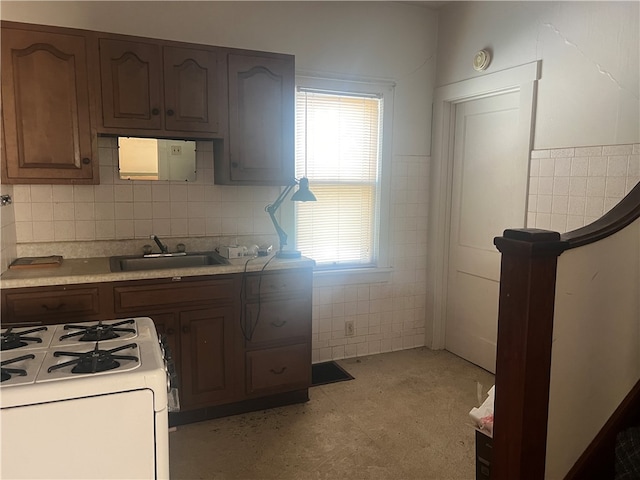 kitchen with tile walls, sink, plenty of natural light, and white gas stove