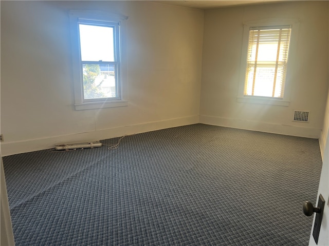 unfurnished room featuring plenty of natural light and carpet flooring