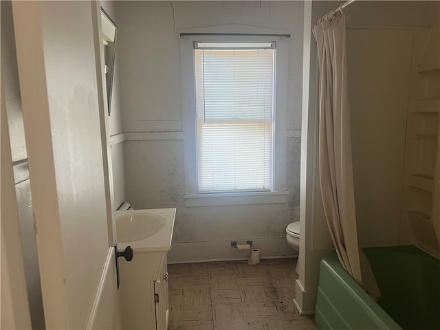 full bathroom featuring a healthy amount of sunlight, vanity, toilet, and shower / bath combo with shower curtain