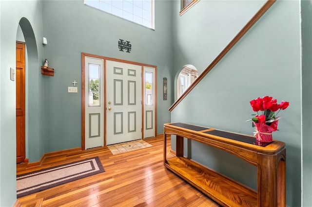 foyer entrance featuring light hardwood / wood-style flooring and a high ceiling