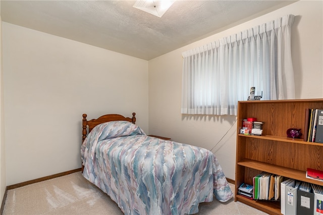 bedroom featuring a textured ceiling and light colored carpet