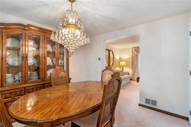 dining area featuring a chandelier and light colored carpet