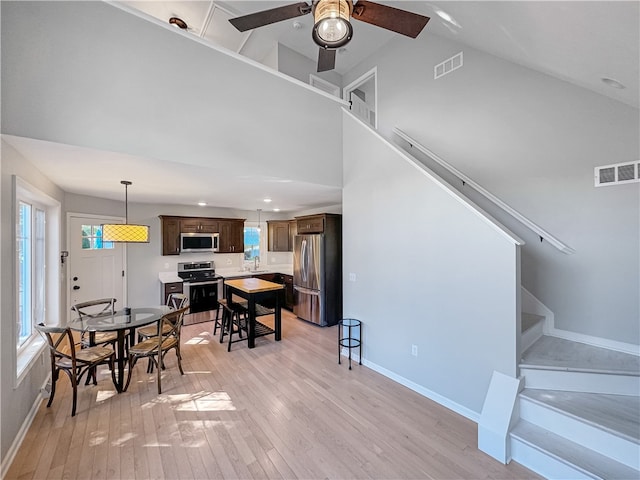 interior space featuring ceiling fan, light hardwood / wood-style flooring, sink, and high vaulted ceiling