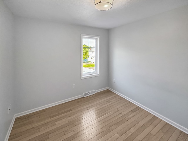 unfurnished room with light wood-type flooring