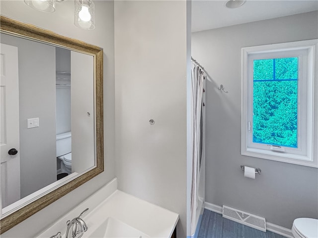 bathroom featuring walk in shower, vanity, and toilet