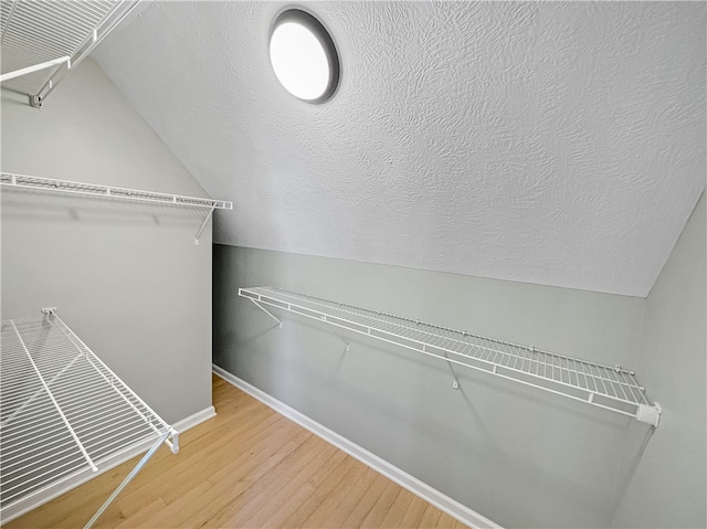 spacious closet featuring wood-type flooring and lofted ceiling