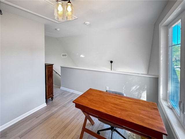 dining area with lofted ceiling, a chandelier, and light hardwood / wood-style floors