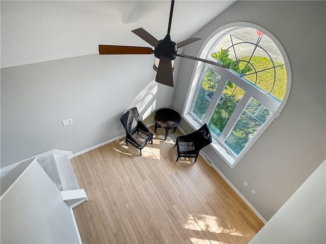 living area featuring ceiling fan, lofted ceiling, and light hardwood / wood-style floors