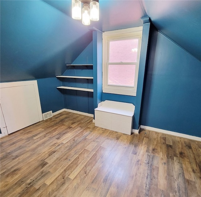 bonus room with lofted ceiling and hardwood / wood-style floors