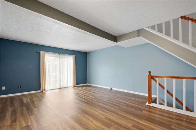 interior space with a textured ceiling and hardwood / wood-style floors