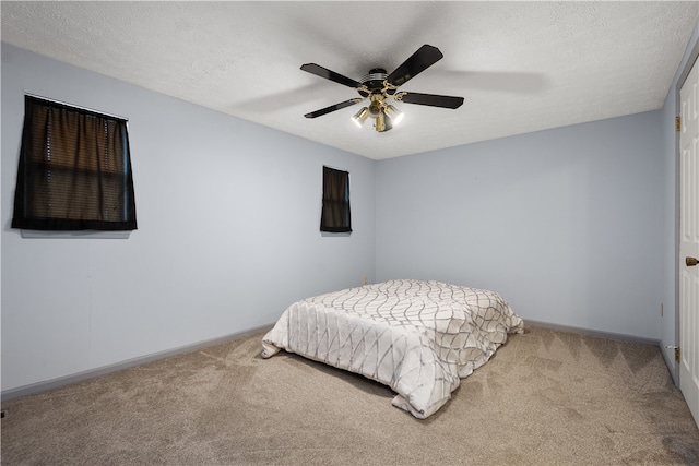 bedroom featuring ceiling fan, a textured ceiling, and carpet