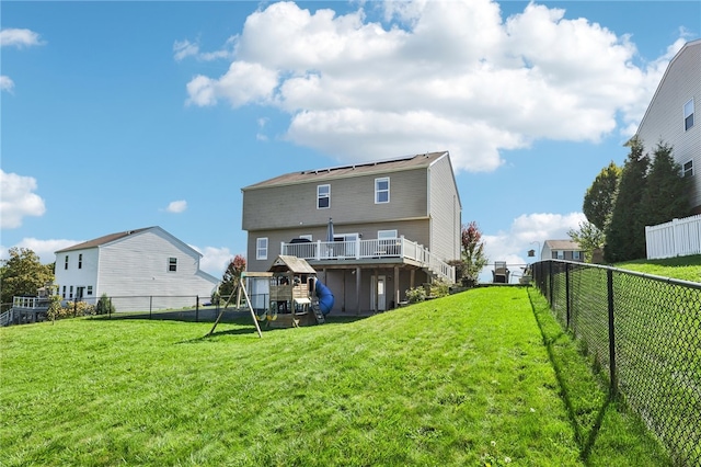 rear view of property featuring a yard and a wooden deck