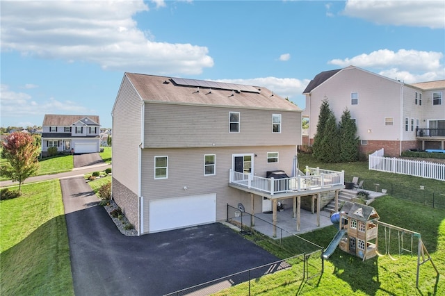 back of house featuring a garage and a yard