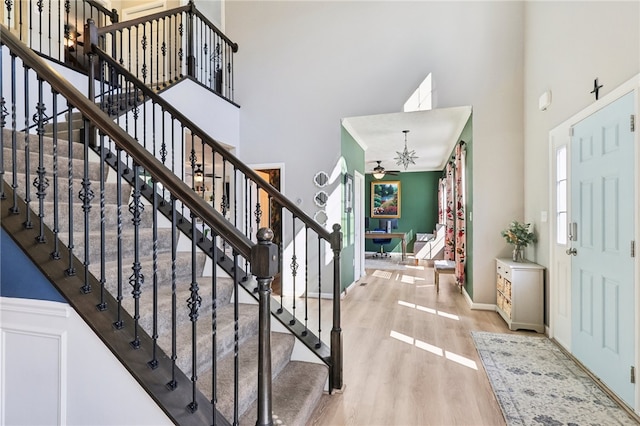 entrance foyer featuring a towering ceiling, a chandelier, and wood-type flooring