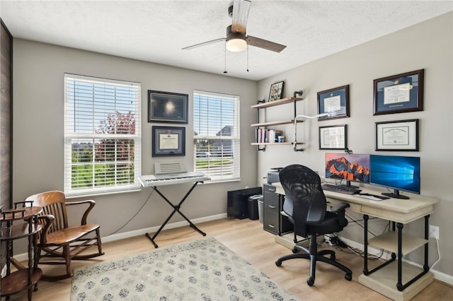 office featuring light wood-type flooring, ceiling fan, and a textured ceiling