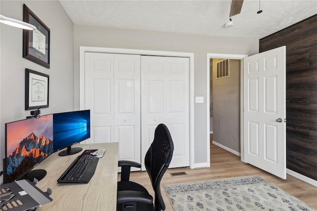 office with wood-type flooring and a textured ceiling