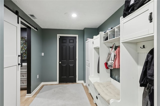 mudroom with light wood-type flooring and a barn door