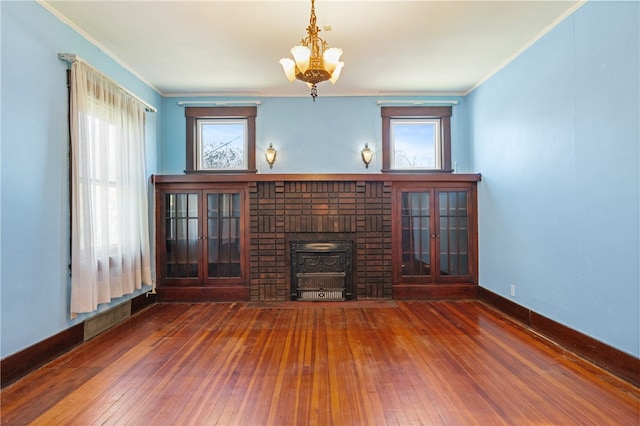 unfurnished living room with dark hardwood / wood-style flooring, a wealth of natural light, and a notable chandelier