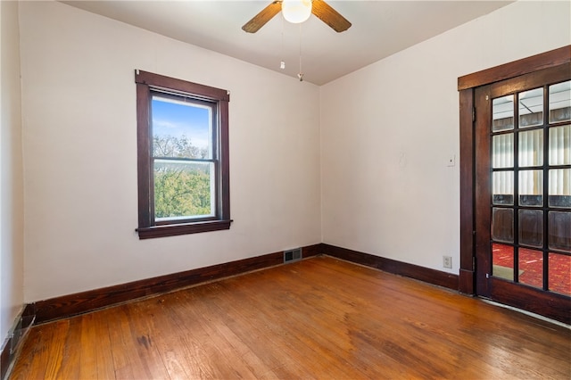 unfurnished room with hardwood / wood-style flooring, a wealth of natural light, and ceiling fan