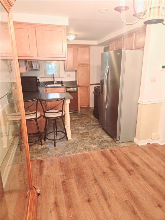 kitchen with dishwasher, dark hardwood / wood-style flooring, light brown cabinets, stainless steel refrigerator with ice dispenser, and sink