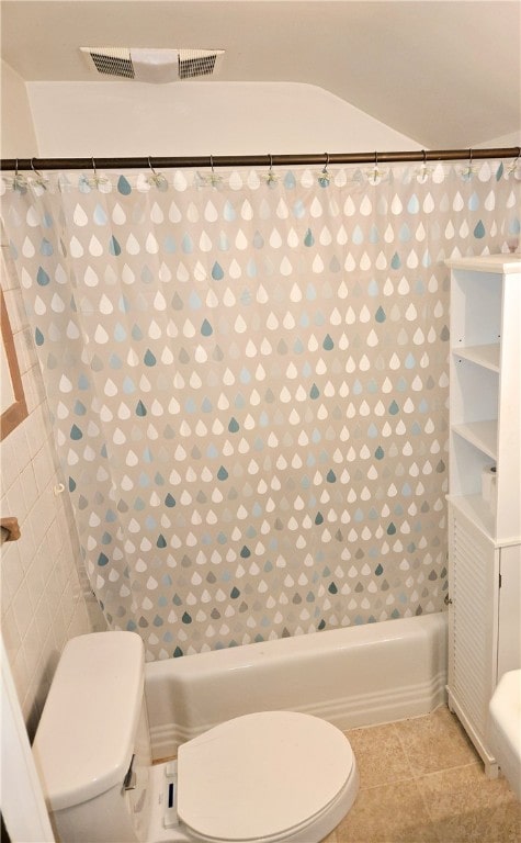 bathroom with tile patterned flooring, shower / bathtub combination with curtain, and toilet