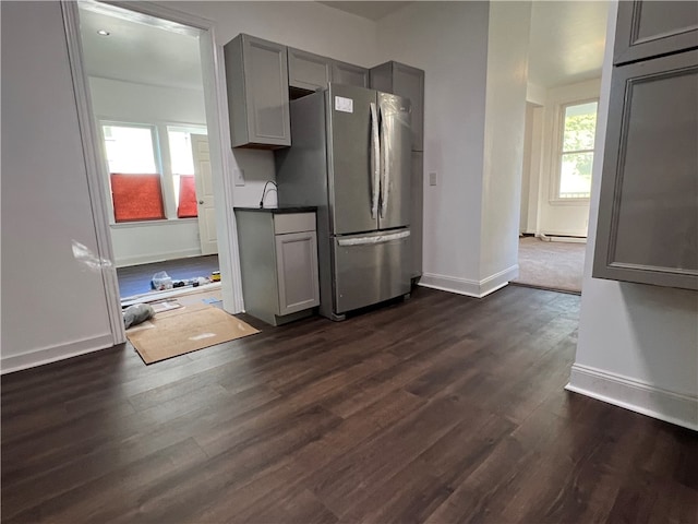 kitchen featuring gray cabinetry, dark hardwood / wood-style flooring, plenty of natural light, and stainless steel fridge