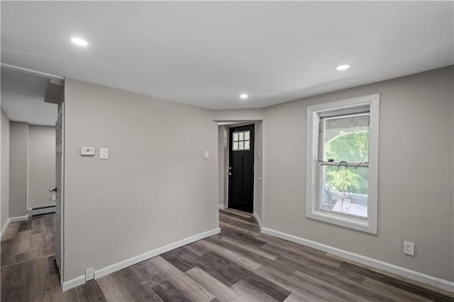 entrance foyer with a baseboard radiator and dark hardwood / wood-style floors