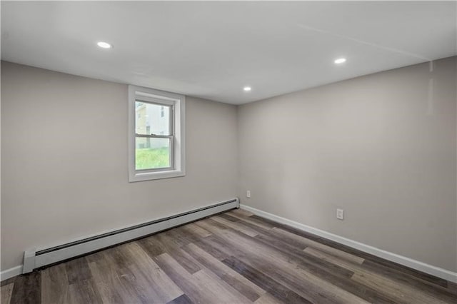 empty room with baseboard heating and hardwood / wood-style floors