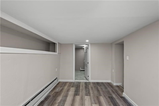 spare room with a baseboard radiator and dark hardwood / wood-style floors