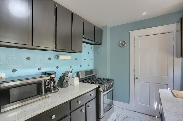 kitchen featuring appliances with stainless steel finishes, backsplash, and gray cabinetry