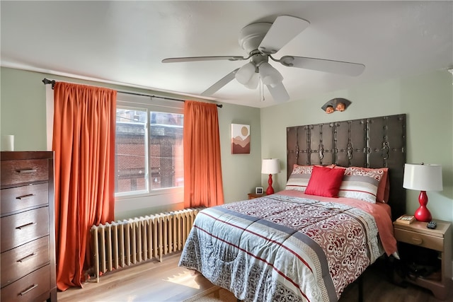 bedroom featuring ceiling fan, radiator, and light hardwood / wood-style flooring