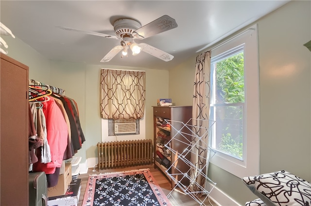 interior space with radiator, ceiling fan, hardwood / wood-style flooring, and cooling unit