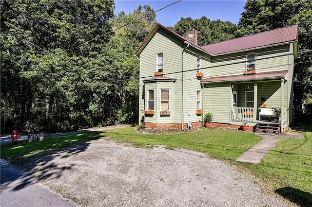 front of property with a front yard and covered porch