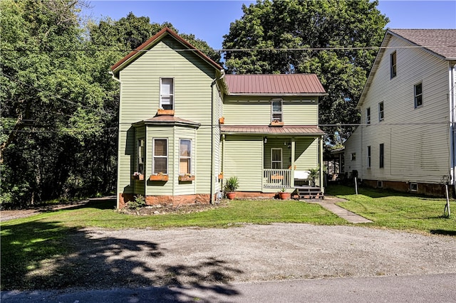 view of front of property featuring covered porch and a front yard