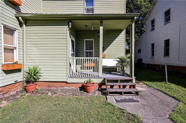 doorway to property with a yard and covered porch